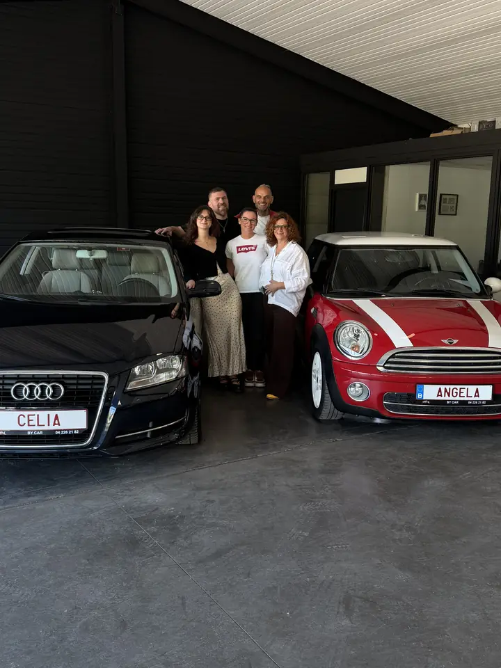Clients BY CAR avec leurs véhicules au showroom