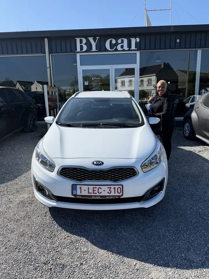 Cliente BY CAR avec son véhicule au showroom